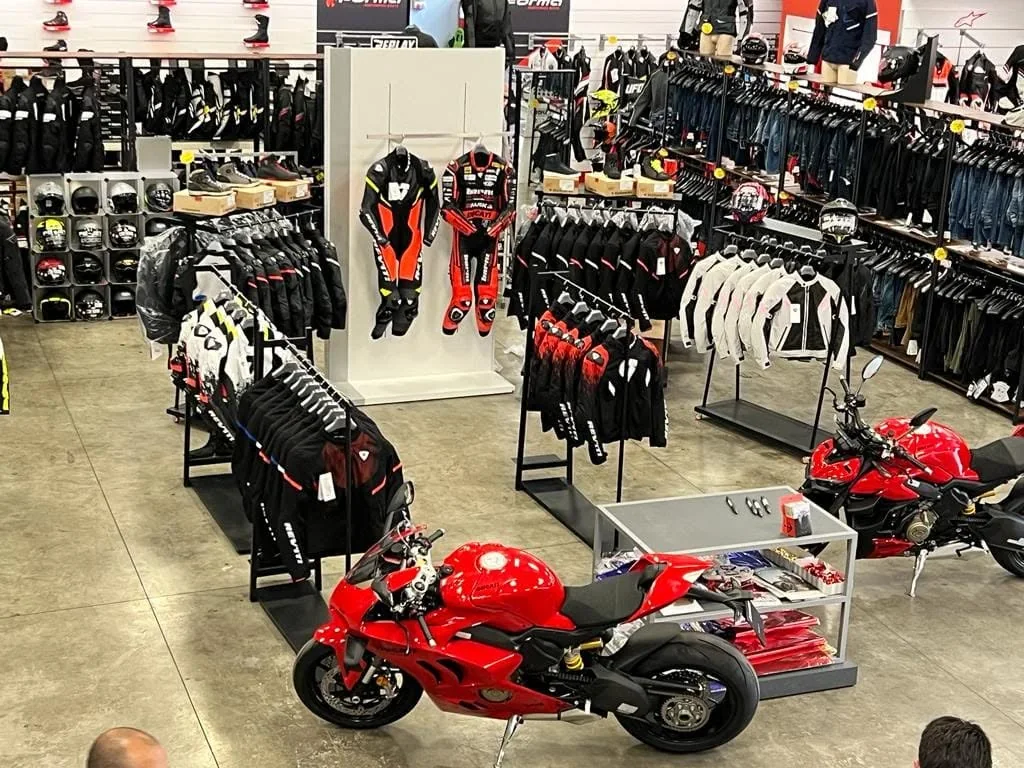 Panoramica del punto vendita TMR Village con abbigliamento e accessori moto